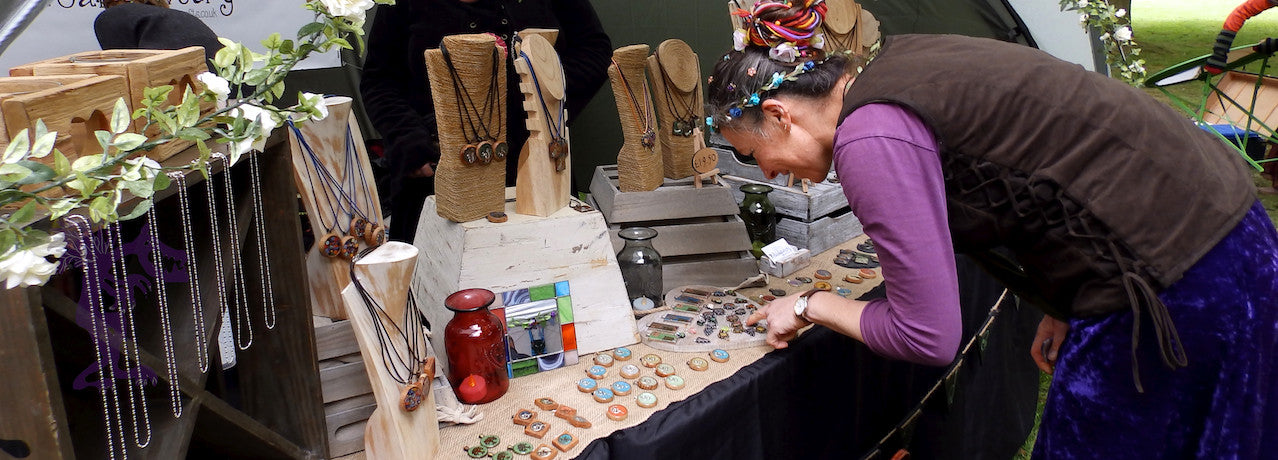 Lady choosing a pendant at Holt Fairy Day (Fairyland Trust)